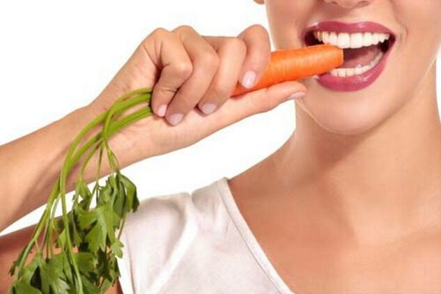 La niña come zanahorias crudas